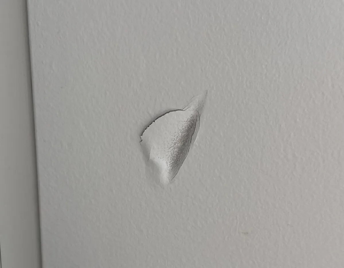 A gouge in the drywall next to the door frame